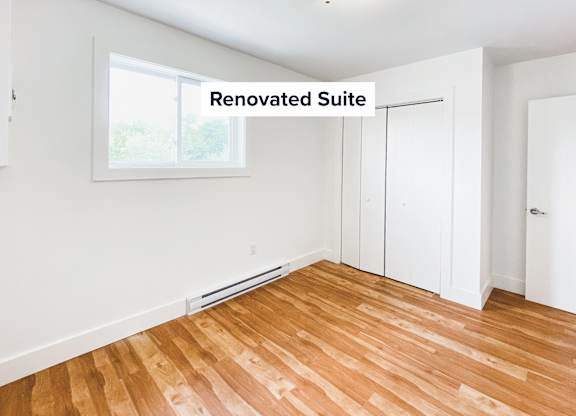 A renovated suite with wooden flooring and white walls.