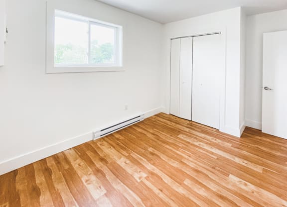 A room with wooden flooring and a window.