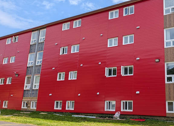 A red building with white windows and a blue sky in the background.