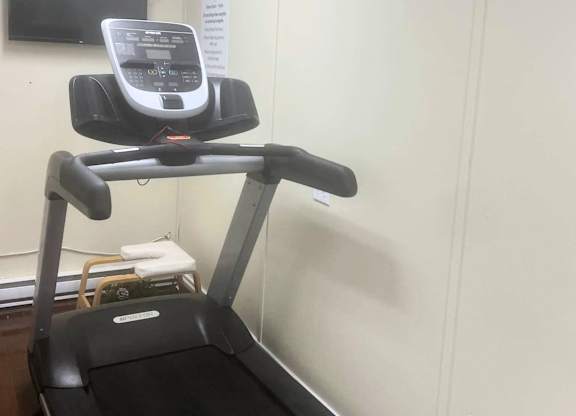 A treadmill with a monitor on top is in a room.