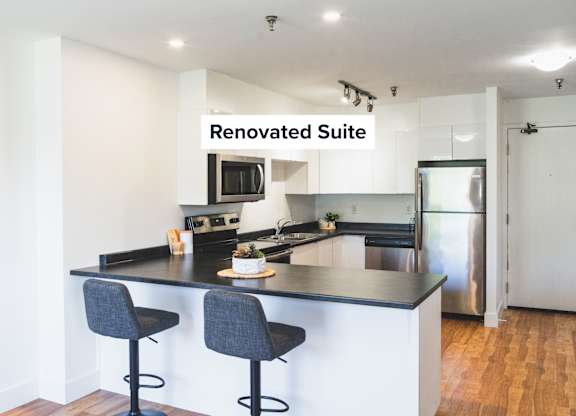 A renovated suite with a kitchen and bar area.