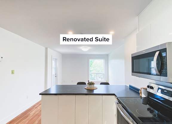 A renovated suite with a black countertop and white cabinets.