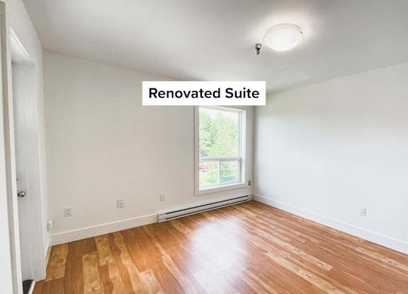 A renovated suite with wooden flooring and a window.