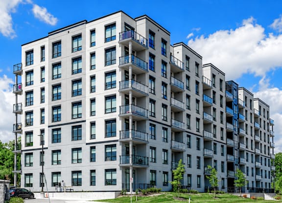A large white apartment building with balconies and multiple windows.