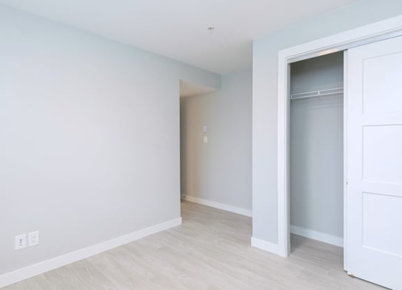 A white door is open in a room with light colored walls and flooring.
