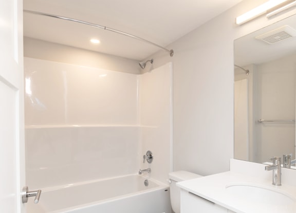 A white bathroom with a toilet, sink, and bathtub.