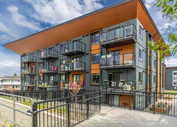 A modern building with black and orange exterior and balconies.