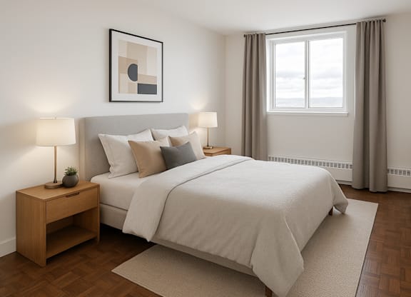 A bedroom with a large bed and a nightstand with a lamp.