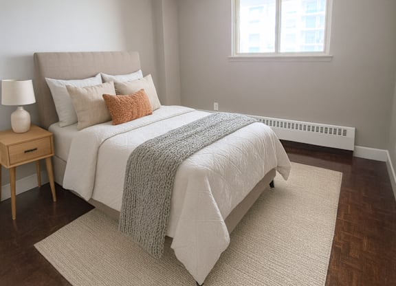 A bedroom with a large bed and a window.