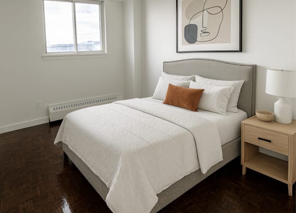 A bedroom with a large bed and a painting above it.