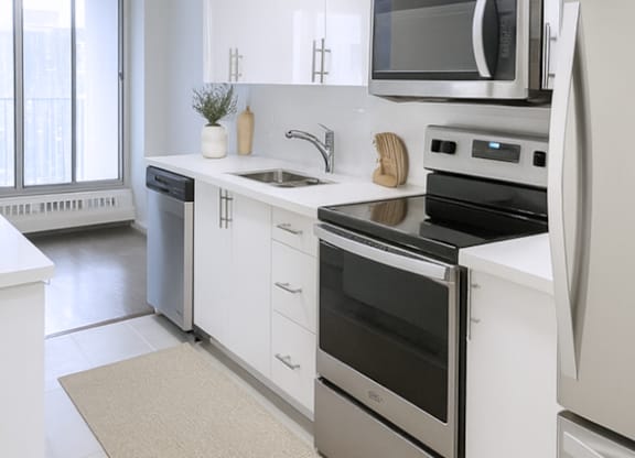 A modern kitchen with stainless steel appliances and white cabinetry.