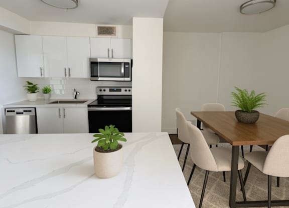 A kitchen with a dining table and chairs.
