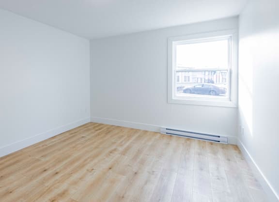 A room with a window and a radiator on the wall.