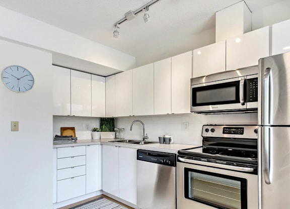 A modern kitchen with stainless steel appliances and white cabinets.
