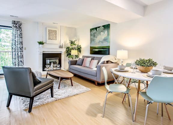 A modern living room with a grey sofa, a black chair, a coffee table, and a fireplace.