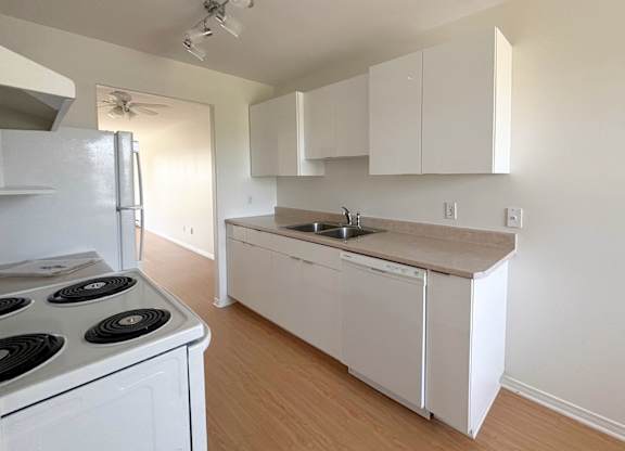 A kitchen with white appliances and cabinets.