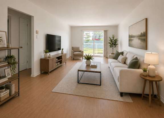 A living room with a white couch, a coffee table, and a television.