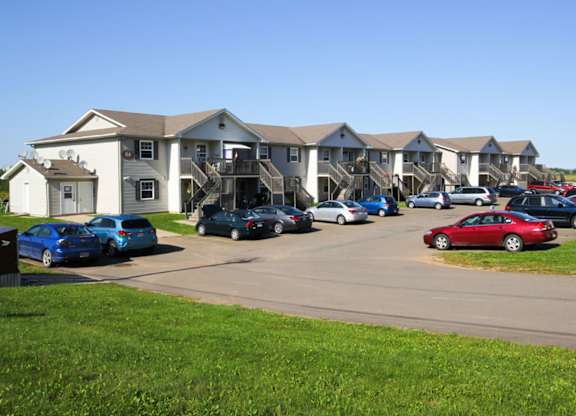 A parking lot with cars and apartment buildings in the background.