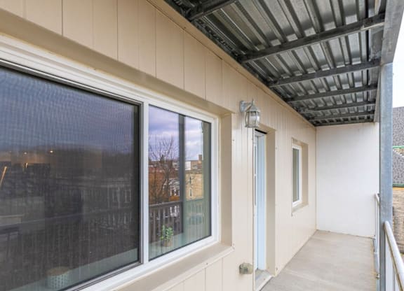 A balcony with a metal railing and a glass door.