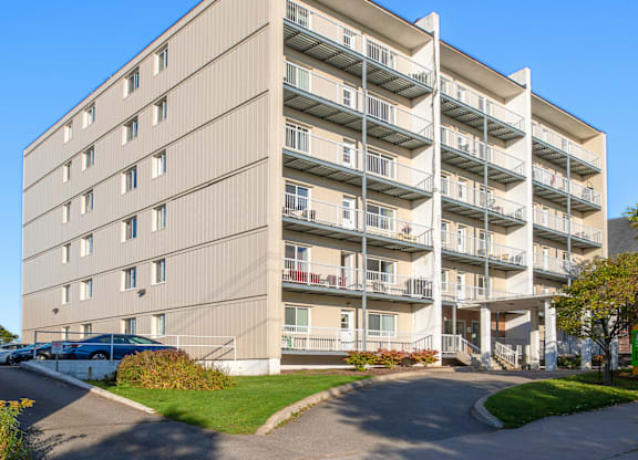 A large apartment building with a parking lot in front.