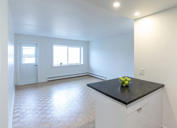 A kitchen with a black countertop and white cabinets.
