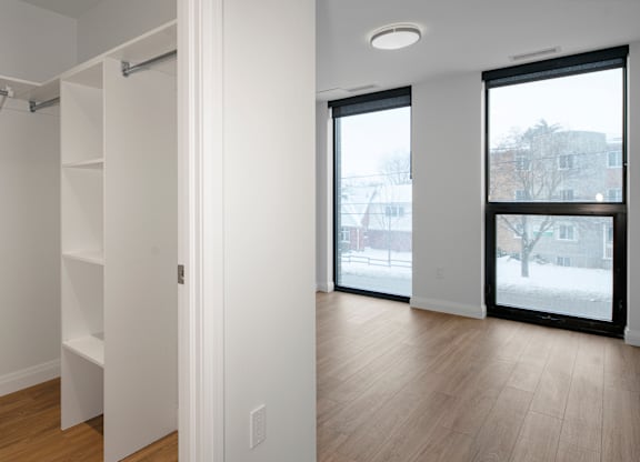 A white room with a sliding door leading to a balcony.