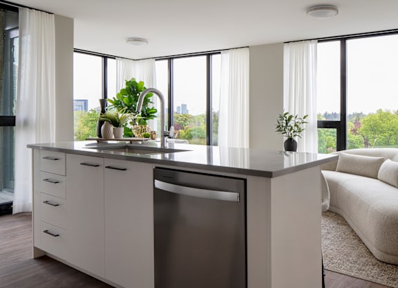 A modern kitchen with a large window overlooking the city.