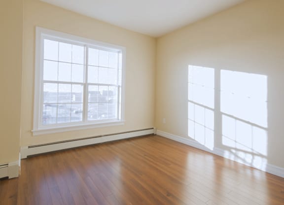 A room with a large window and wooden flooring.