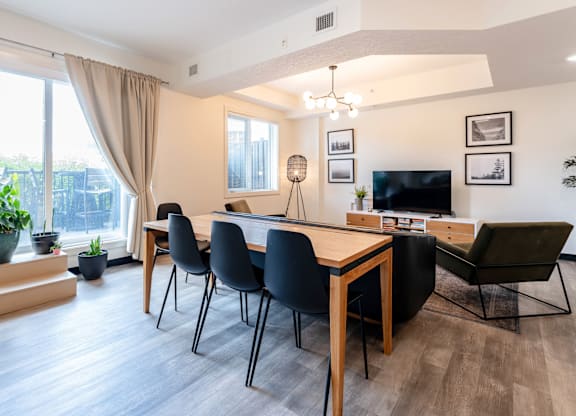 A modern dining room with a wooden table and chairs.