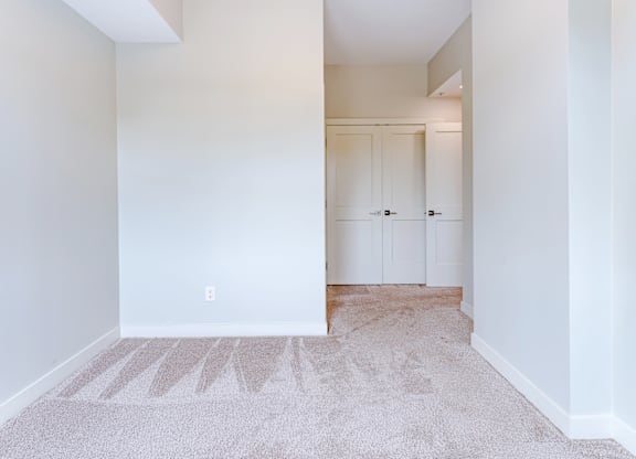 A room with white walls and a carpet with a design on it.