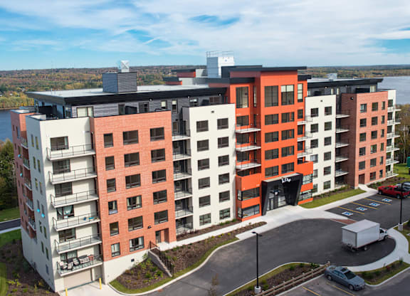 A modern multi-story apartment building with a mix of red and white balconies.