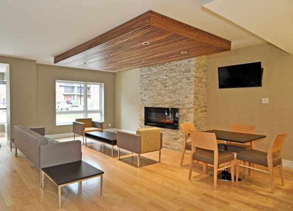 A modern living room with a stone fireplace and a television.