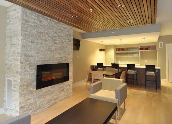 A modern living room with a stone fireplace and wooden ceiling.