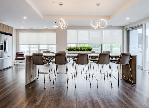 A modern dining room with a long table and chairs.