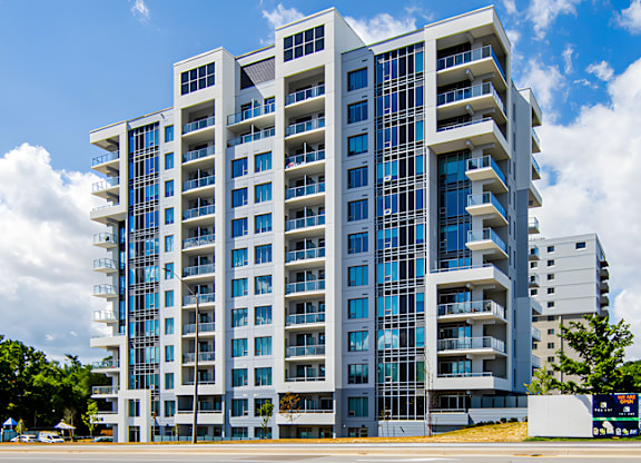 A modern multi-story building with balconies and large windows.