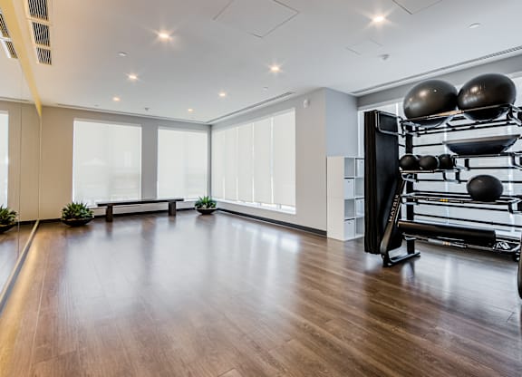 A spacious room with a pilates reformer and a bench.