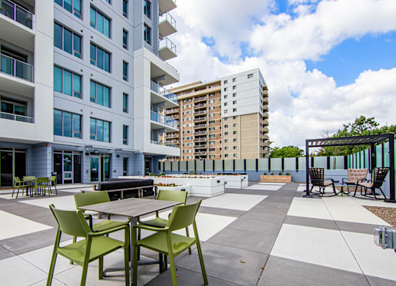 A patio with a table and chairs is in front of a building.