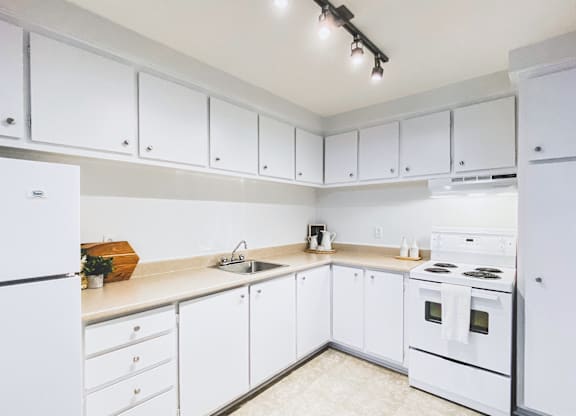 A kitchen with white appliances and cabinets.