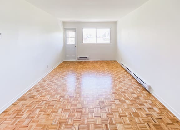 A room with a wooden floor and a white door.