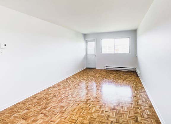 A room with a wooden floor and white walls.