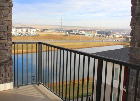 A balcony with a view of a field and buildings.