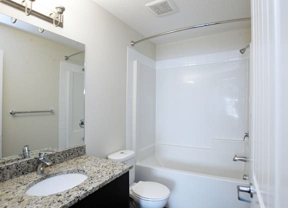 A white bathroom with a sink, toilet, and bathtub.