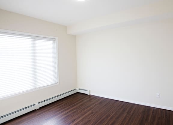 A room with a window and wooden floors.