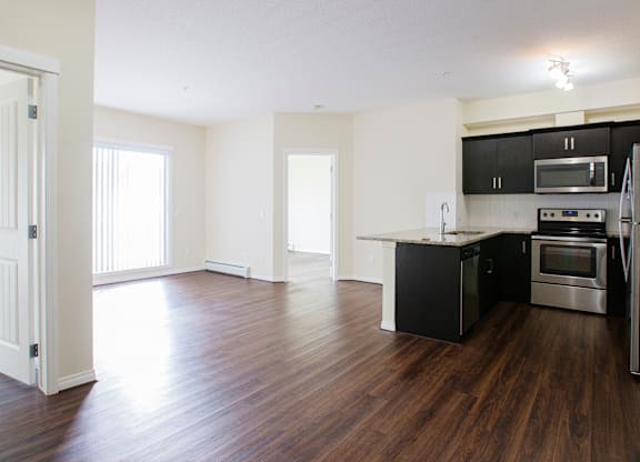 A kitchen with black cabinets and stainless steel appliances.