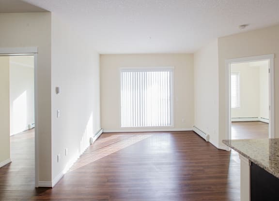 A large empty room with wooden floors and white walls.