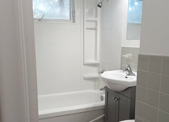 A white bathroom with a sink, toilet, and bathtub.