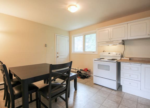 A kitchen with a table and chairs.