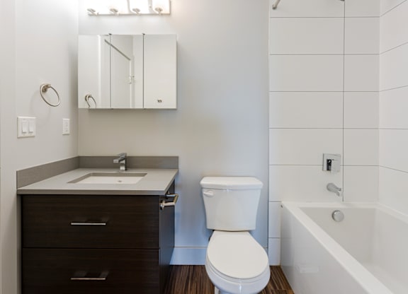 A white toilet sits next to a sink in a bathroom.