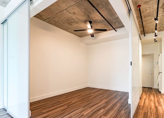 A room with wooden flooring and a ceiling fan.