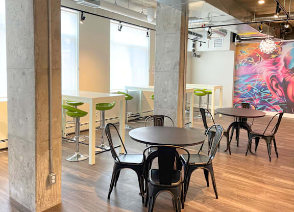 A modern dining area with a large mural on the wall.